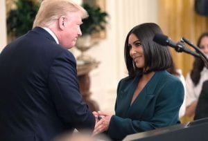 Kim Kardashian shakes hands with President Donald Trump after a press conference.